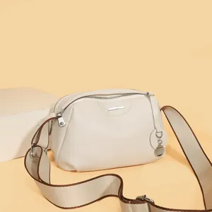 White leather crossbody bag for women, stylish daily shoulder handbag with wide canvas strap.