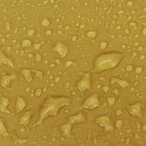 Water-repellent nylon fabric detail shot showing beaded water droplets on yellow surface.