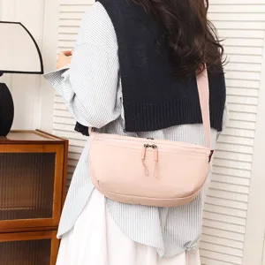 Pink nylon crossbody bag for women, lightweight casual sling bag with zipper and wide strap.