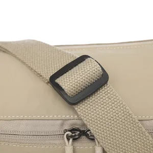 Close up view of adjustable shoulder strap buckle and durable nylon fabric detail on messenger bag.