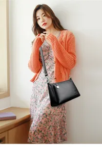 Sac à bandoulière noir classique en cuir souple pour femme au style élégant et chic.