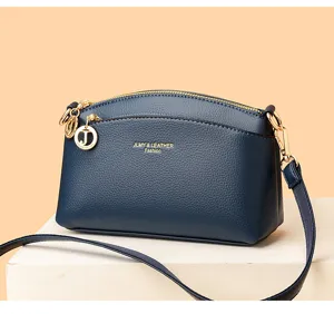 Navy blue dome crossbody bag for women, stylish leather shoulder bag with gold hardware.