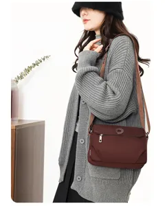 Detail view of casual women nylon crossbody bag in dark brown with adjustable strap.