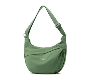 Detailed view of green nylon crossbody bag with adjustable strap and front zipper pocket.