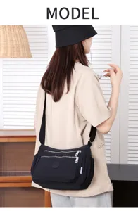 Black nylon crossbody bag with multi pockets and zip compartments for daily casual use.