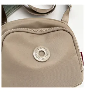 Lightweight nylon crossbody bag detail, casual commuter shell shoulder bag in khaki color.