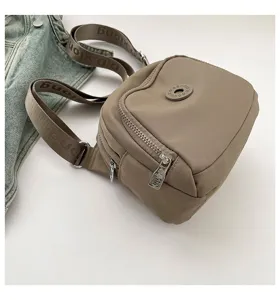 Detail view of the casual nylon crossbody bag in khaki, featuring a front pocket and strap.