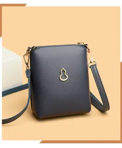 Detailed view of the stylish dark grey crossbody phone bag with gold gourd metal emblem.