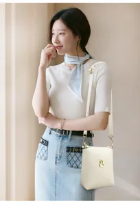 Detail view of the Korean style crossbody phone bag in off-white leather with cute gourd hardware.