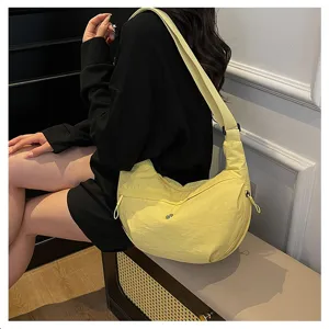 Detail view of yellow nylon crescent shoulder bag, lightweight casual crossbody bag.