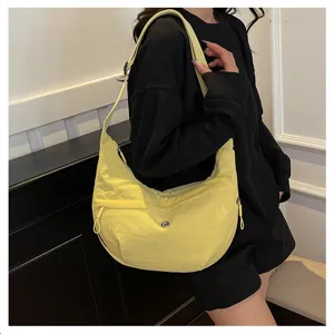 Detail view of the bright yellow nylon crossbody shoulder bag, lightweight waterproof design.