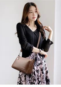 Vue détaillée du sac à bandoulière élégant en cuir souple avec texture fine et accessoires.