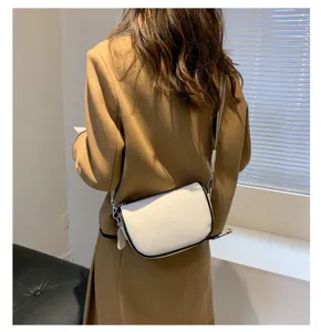 Elegante borsa tracolla da donna in pelle bianca con bordo nero chic e tracolla.