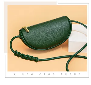 Close-up detail of the dark green crescent leather shoulder bag featuring unique braided strap.