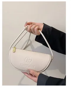 Close-up detail of white crescent leather shoulder bag, minimalist crescent shape design.