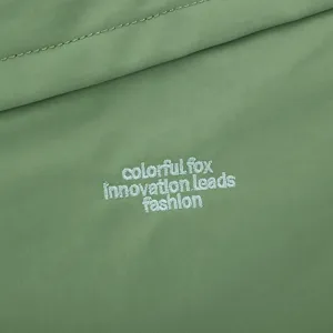 Nylon crossbody bag fabric detail shot showing green texture and embroidered fashion logo text.