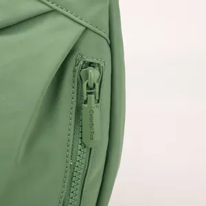 Green nylon crossbody bag zipper detail, lightweight casual shoulder bag accessory view.