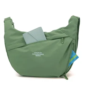 Green nylon crossbody bag detail showcasing multiple zipper pockets and card slot storage.