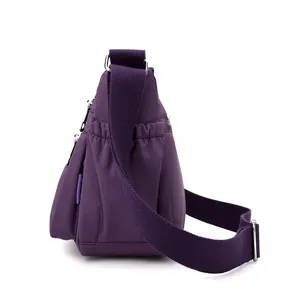 Detailed side view of the purple nylon crossbody bag, showing durable fabric and strap.