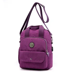 Mochila convertible de nailon morado bolso bandolera informal con puerto USB y bolsillos.