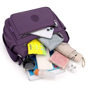 Detailed view of large capacity purple nylon crossbody bag with multi-pocket storage.