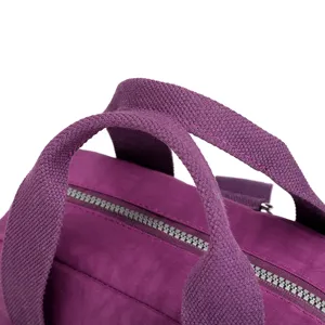 Detalle de mochila de nylon violeta, mostrando tela resistente, asas y cremallera suave.
