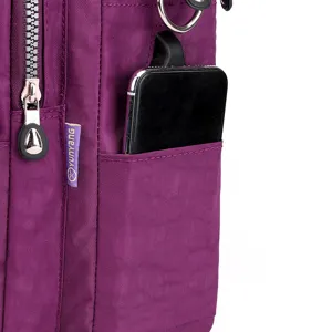Detalle lateral mochila nailon, bolsillo con cremallera para móvil y anillo metálico.