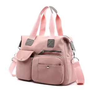 Gedetailleerd overzicht van de roze nylon tas met meerdere vakken en sterke handgrepen.