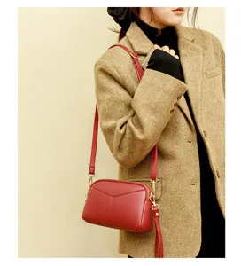 Close-up detail of red PU leather crossbody shoulder bag worn by model, chic style.