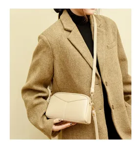Detail view of a stylish beige PU leather crossbody bag, soft texture, simple and chic.