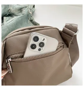 Casual nylon crossbody bag with front zipper pocket, lightweight commuter shoulder bag.