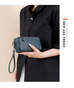 Detail shot of genuine leather clutch handbag, metal zipper, elegant wrist strap design.