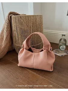 Detail shot of the stylish pink pleated cloud bag, showcasing its elegant texture and hardware.