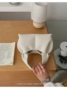 Detailed view of fashionable vintage pleated cloud shoulder bag in elegant off-white color.