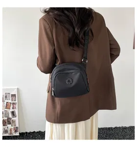Casual nylon crossbody bag for women, lightweight black shoulder bag for daily use.