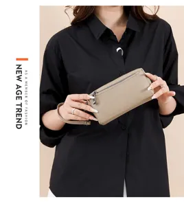 Detailed view of genuine leather women clutch bag with wrist strap, zipper pocket design.