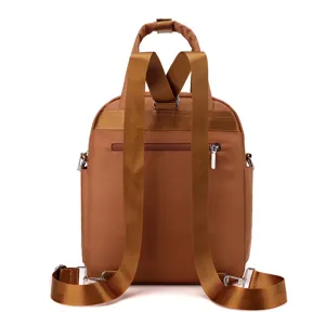 Back detail of brown nylon backpack showing adjustable straps and secure zip pocket.