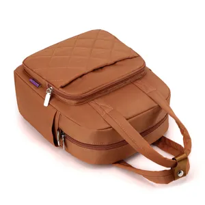 Detailed view of the brown quilted nylon backpack, featuring durable zippers and top handles.