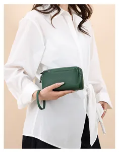 Detail of dark green genuine leather women wrist bag with zipper and strap, premium cowhide.