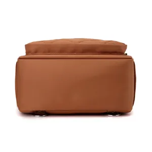 Brown nylon backpack detail view, quilted design, durable student daypack and casual shoulder bag.