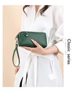 Green genuine leather clutch bag for women, compact zipper phone pouch with wrist strap detail.
