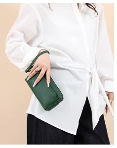 Close-up detail of the green genuine leather zipper phone wristlet bag, exquisite texture.