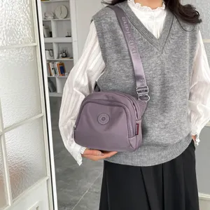 Casual nylon crossbody bag for women, lightweight commuter shell shoulder bag with wide strap.