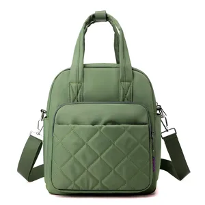Green nylon backpack with diamond stitching, top handle and convertible shoulder straps for women.