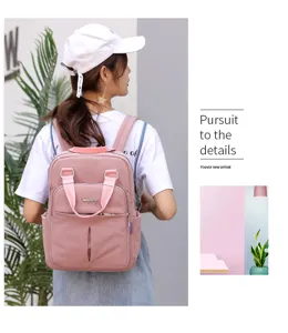 Detail view of stylish pink women casual backpack featuring top handle and pockets.