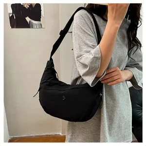 Detail view of a black nylon crossbody bag worn by a model, casual style, daily use.