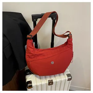 Detailed view of the red nylon crescent crossbody shoulder bag, lightweight travel lifestyle.
