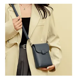 Primer plano detallado del bolso cruzado vertical azul oscuro para mujer con elegante textura.