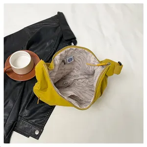 Detail view of large capacity yellow nylon shoulder bag showing interior lining and pockets.