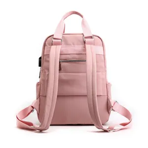 Pink casual backpack for women, travel daypack with USB charging port and multiple pockets.